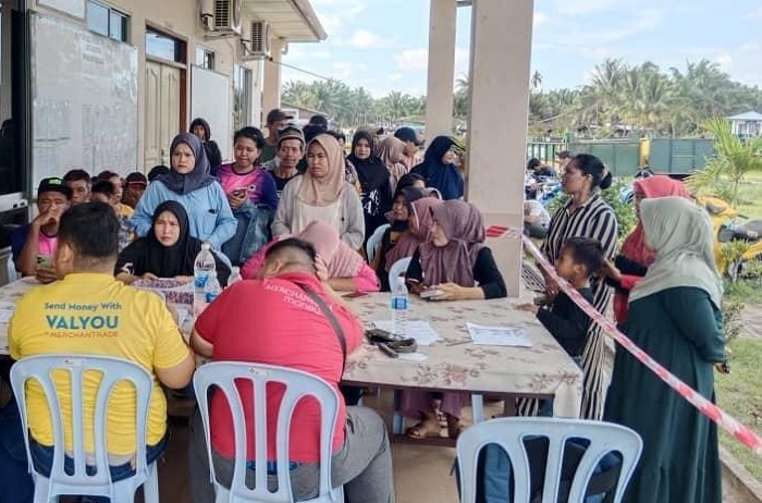 Signing up migrant workers at an Oil Palm Plantation.